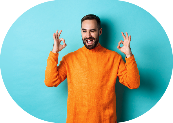 Man wearing an orange sweater winking and making the okay gesture with both hands against a light blue background.